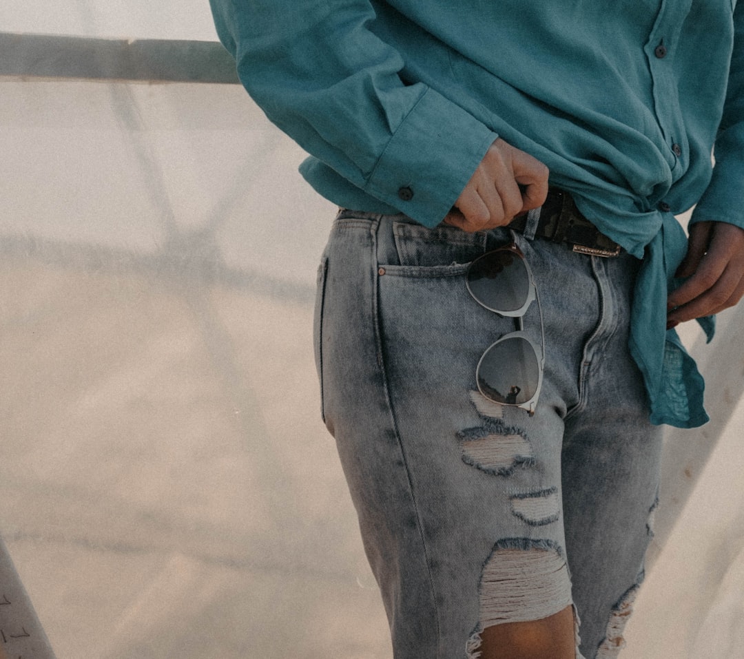 Vervet High-Rise Distressed Jeans - a woman wearing a blue shirt and ripped jeans