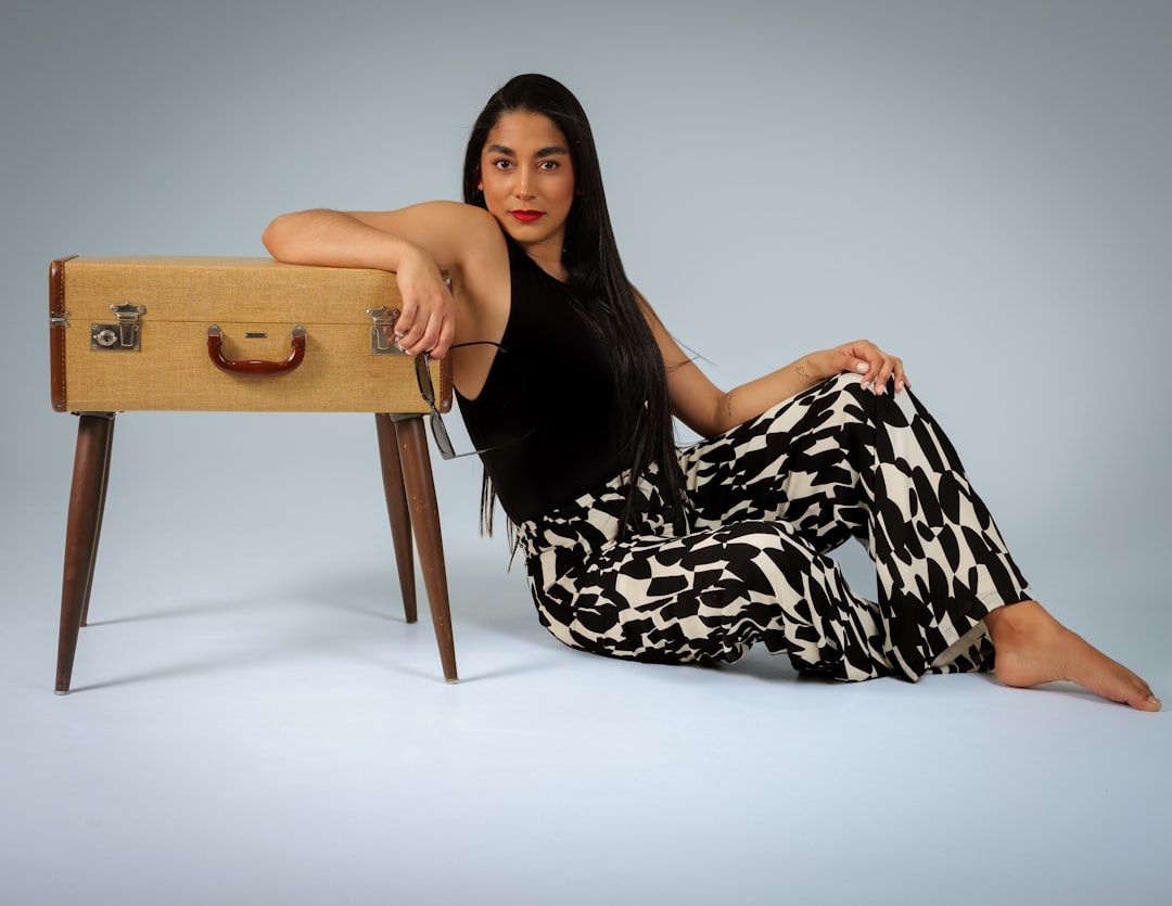 Vervet Wide Leg Jeans: Fit Review After Three Months - Woman sitting next to a vintage suitcase